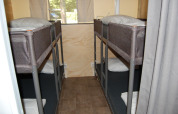 Four sleeping spots in bunk beds inside a safari tent cabin at Glampingtent Cahors, La Draille, France.