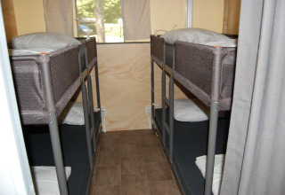 Vier slaapplaatsen in stapelbedden binnenin een safaritent bij Glampingtent Cahors, La Draille, Frankrijk.
