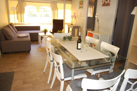 Vista interior de la tienda Glampingtent Cahors en La Draille, Francia, con mesa de comedor y sofá.