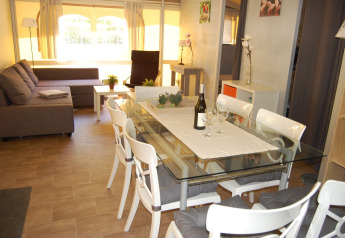 Vista interior de la tienda Glampingtent Cahors en La Draille, Francia, con mesa de comedor y sofá.