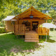 Safari tent Lodgetent Brive at La Draille in France with wooden deck and umbrella, surrounded by nature.