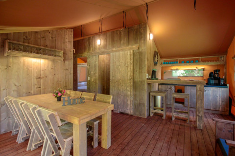 Interior of Lodgetent Brive at La Draille in France, featuring rustic wooden furniture and cozy lighting.