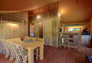 Interior of Lodgetent Brive at La Draille in France, featuring rustic wooden furniture and cozy lighting.