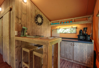 Rustikaler Küchenbereich mit Holzmöbeln und Küchengeräten im Lodgetent Brive bei La Draille, Frankreich.