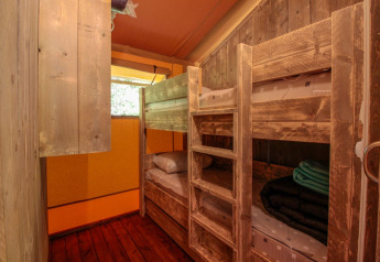 Intérieur de la Lodgetent Brive à La Draille en France, chambre rustique avec lits superposés en bois.