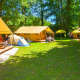 Folk slapper af og spiller bold foran Lodgetent St. Emilion Deluxe på La Draille campingplads i Frankrig.