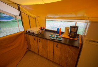 Coin cuisine dans la tente safari Lodgetent St. Emilion Deluxe à La Draille avec cafetière et plaques visibles.