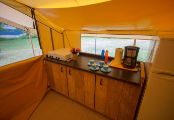 Coin cuisine dans la tente safari Lodgetent St. Emilion Deluxe à La Draille avec cafetière et plaques visibles.