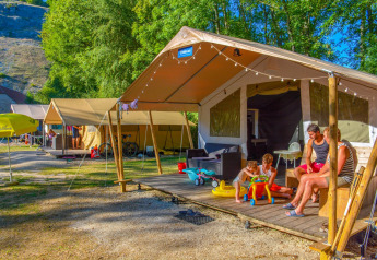 Une famille profite de ses vacances près d'une tente safari à Lodgetent St. Emilion Deluxe, La Draille, France.