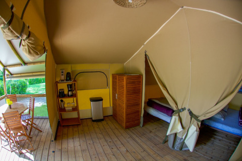 Tienda safari Lodgetent Gourdon en La Draille, Francia, con suelo de madera, camas y zona de comedor.