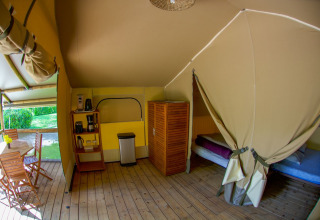 Tienda safari Lodgetent Gourdon en La Draille, Francia, con suelo de madera, camas y zona de comedor.