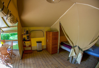 Tente safari Lodgetent Gourdon à La Draille en France, avec plancher bois, lits et coin repas extérieur.