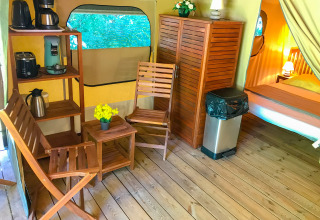 Interior of Lodgetent Gourdon safari tent at La Draille, France, with wooden furniture and appliances.