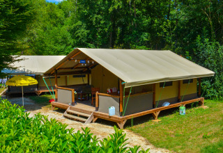 Safari tent Lodgetent Gourdon at La Draille in France, surrounded by lush greenery and sunshine in summer.
