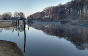 Uitzicht op de rivier bij de River Lodge op Camping de Koeksebelt in Nederland, met berijpte bomen.