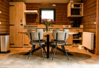 Moderne keuken met eethoek bij River Lodge op Camping de Koeksebelt, Nederland, met houten interieur.