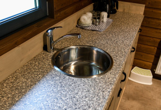 Fregadero redondo en encimera de granito en River Lodge, Camping de Koeksebelt, Países Bajos, tazas atrás.