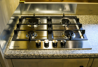 Cocina de gas de cuatro fuegos sobre encimera de granito en River Lodge, Camping de Koeksebelt, Países Bajos.