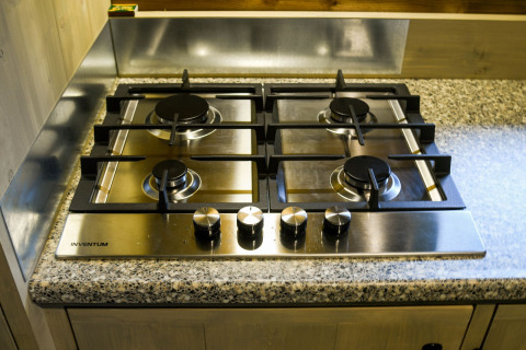 Cocina de gas de cuatro fuegos sobre encimera de granito en River Lodge, Camping de Koeksebelt, Países Bajos.