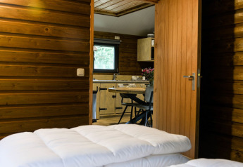 Vista interna della River Lodge al Camping de Koeksebelt nei Paesi Bassi, con cucina e pareti in legno.