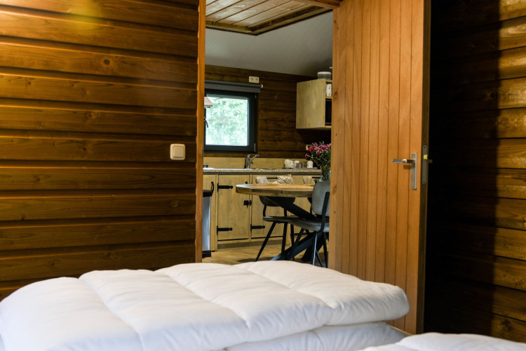 Innenansicht der River Lodge auf Camping de Koeksebelt in den Niederlanden, mit Küche und Holzwänden.