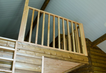 Vue intérieure d’une mezzanine en bois avec rambarde à River Lodge, Camping de Koeksebelt, Pays-Bas.