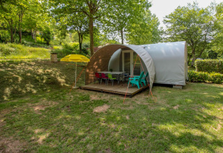 Tienda safari Le Petit Chateau en La Draille, Francia, rodeada de árboles y mobiliario exterior.