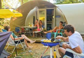 Familie genießt eine Mahlzeit vor dem Safarizelt Le Petit Chateau bei La Draille in Frankreich.