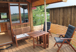 Terraza de madera con mobiliario exterior en River Cottage, Camping de Koeksebelt, Países Bajos, naturaleza.