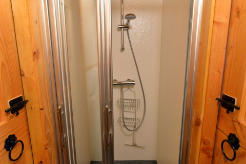 Douche au River Cottage, Camping de Koeksebelt, Pays-Bas, avec portes vitrées et douchette moderne.