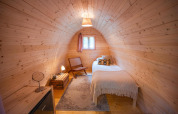 Habitación de cápsula Solo en RØSTIG, Países Bajos, con cama individual, decoración de madera y ventana.
