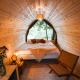 Premium Duo Panorama Pod at RØSTIG in the Netherlands with wooden walls, cozy bed, and lake view.
