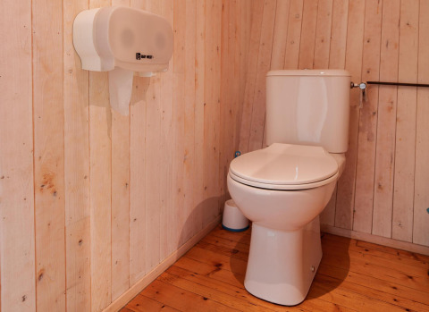 Toilet i træbeklædt badeværelse på Luxe & Lazy Lodge, RØSTIG Dorst, Holland, set fra siden.