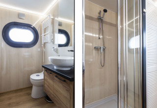 Baño moderno en la casa flotante 'Iere Fügel' con ventana redonda, lavabo, inodoro y ducha en Frisia.
