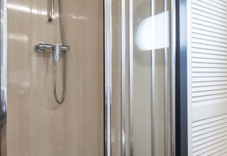 Cabina de ducha moderna con puertas de vidrio en la casa flotante 'Iere Fügel' en Friesland, Países Bajos.