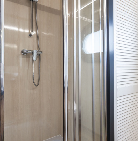 Cabine de douche moderne avec portes vitrées à bord de la péniche 'Iere Fügel' à Friesland, Pays-Bas.