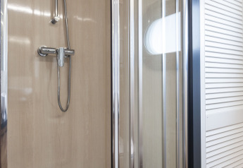 Cabina de ducha moderna con puertas de vidrio en la casa flotante 'Iere Fügel' en Friesland, Países Bajos.