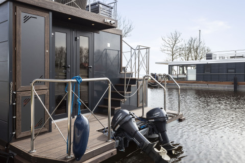 Casa flotante 'Iere Fügel' en Welcome In - Friesland, Países Bajos, con motores Yamaha junto al agua.