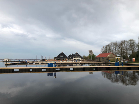 Blick auf einen ruhigen Hafen mit Hausbooten bei Welcome In - Friesland, Niederlande, bei Wolkenhimmel.