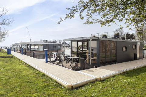 Woonboot 'Iere Fügel' bij Welcome In - Friesland, aangemeerd aan een steiger in Nederland.