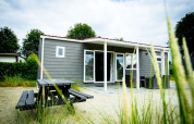 Vista exterior de una Dune Lodge moderna con terraza en Holiday Park Duinhoeve, en los Países Bajos.