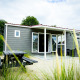 Udendørsbillede af en moderne Dune Lodge med træbeklædning og terrasse på Holiday Park Duinhoeve i Holland.