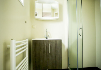 Modernes Badezimmer mit Dusche, Waschbecken, Schrank und Spiegel in der Dune Lodge im Holiday Park Duinhoeve.