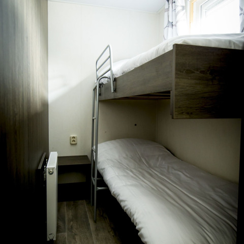Kleine kamer met stapelbed en modern interieur in Dune Lodge bij Holiday Park Duinhoeve, Nederland.