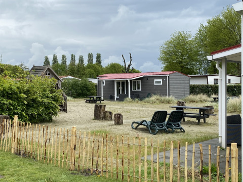 Außenansicht von Dune Lodge im Holiday Park Duinhoeve, Niederlande, mit Garten und Sitzgelegenheiten.