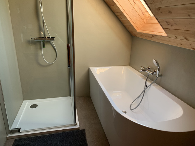 Baño moderno en Heydehuis con ducha y bañera bajo techo inclinado, Sandberghe, Países Bajos.