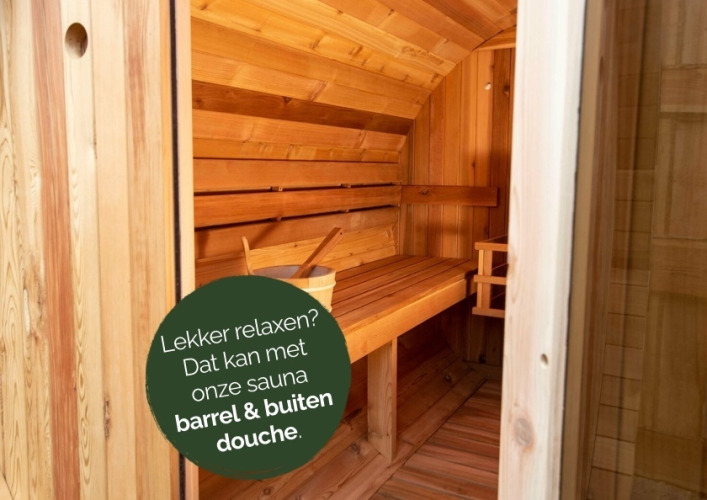 Barrelsauna van hout met bank en emmer, perfect om te ontspannen tijdens een glampingverblijf.