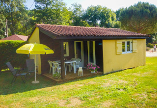 Foto af Chalet Borrèze ved La Draille i Frankrig, med terrasse, havemøbler og gul parasol i haven.