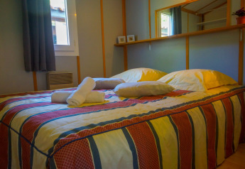 Dormitorio en Chalet Borrèze, La Draille, Francia, con cama doble, almohadas, toallas y un espejo grande.