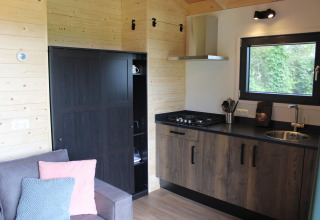 Cocina y sala compacta en la tiny house Cuckoo's Nest en Camping de Koeksebelt, Países Bajos.